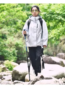 Bastone da trekking regolabile in alluminio impugnato da un escursionista nel bosco