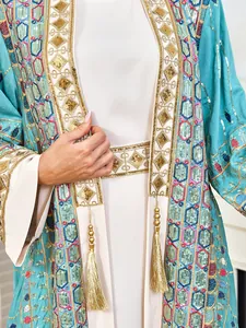 Close-up of heavy-duty sequin embroidery and gold tassels on elegant kaftan