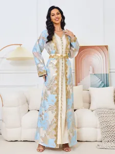 Detailed view of luxury long kaftan dress with heavy gold embroidery and blue flowers