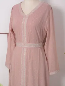 Gros plan d'une robe rose à manches longues avec rayures argentées et col en V pailleté