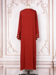 Vue arrière d'une robe longue rouge élégante avec des manches brodées de sequins sur un mannequin.