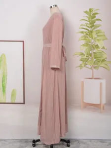 Vue de côté d'une élégante robe longue rose avec rayures argentées et poignets perlés.