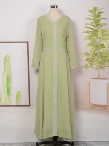 Vue détaillée d'une robe longue vert clair à manches longues sur un mannequin