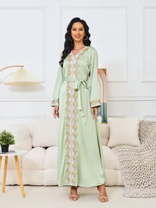 Vista completa del elegante vestido maxi verde menta con bordado dorado en el salón