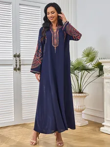 Detalle de un elegante vestido largo azul marino con bordados étnicos vibrantes en las mangas.