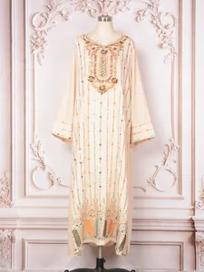 Robe longue champagne élégante avec broderies et paillettes complexes sur l'encolure.