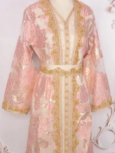 Detailed view of pink Moroccan kaftan with gold embroidery and floral metallic fabric