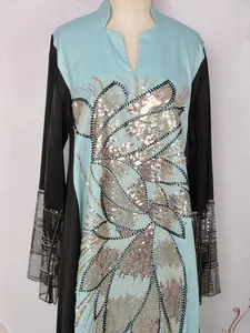 Détail d'une robe longue ethnique avec paillettes et appliques de perles brodées