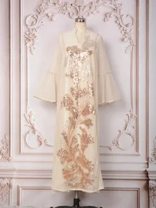 Vue détaillée d'une robe crème de luxe avec broderie complexe de paillettes dorées