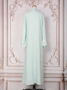 Vue arrière d'une robe maxi élégante vert menthe avec poignets brodés de paillettes