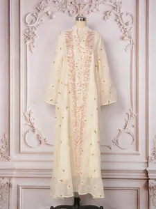 Dettaglio dell'abito lungo in mesh ricamato con paillettes e perline color oro