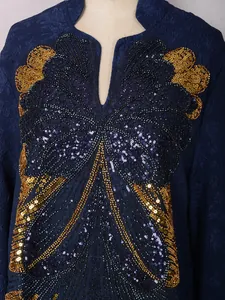 Macro view of the elegant navy blue dress with intricate gold and black sequin embroidery