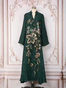 Robe longue vert foncé élégante avec broderie florale en paillettes dorées sur mannequin.