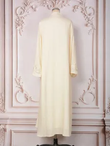 Vue arrière de l'élégante robe maxi crème avec des détails perlés sur les manches