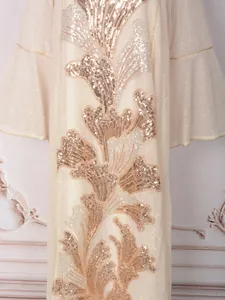 Gros plan d'une robe crème élégante avec broderie florale complexe de paillettes dorées