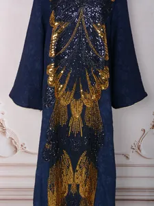 Intricate close-up of heavy gold sequin butterfly embroidery on a navy evening dress
