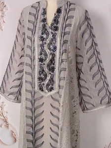 Detailed view of ethnic long dress with sequins and bead embroidery on mesh sleeves.