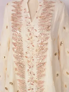 Dettaglio del ricamo di paillettes oro rosa su abito casual in rete bianca chic