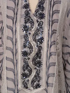 Detailed view of ethnic mesh dress featuring intricate sequin embroidery and beadwork