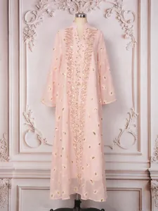 Dettaglio dell'elegante abito lungo in rete rosa con ricami di paillettes floreali e perline.