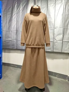 Detail view of minimalist fleece turtleneck sweatshirt and long skirt set in tan