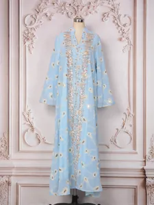 Elegante caftano in mesh azzurro con ricami floreali dorati e paillettes su manichino