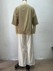 Rückansicht eines böhmischen Sets aus khakifarbenem Top und weißer Hose auf Schaufensterpuppe.