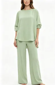 Donna in completo da casa due pezzi verde salvia con top oversize e pantaloni a gamba larga