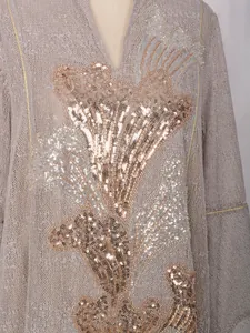 Gros plan d'une robe en maille taupe élégante avec broderie de paillettes et de perles