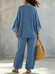 Detail back view of a blue polka dot batwing sleeve blouse and matching trousers set