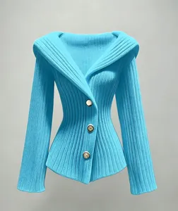 Vue détaillée de la texture tricotée bleu vif et des boutons dorés de ce cardigan cintré