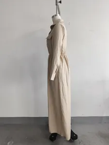 Zijaanzicht van een Franse beige maxi-jurk met ritskraag en elastische tailleband.