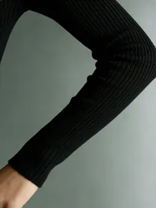Primo piano della manica in maglia a coste nera con trama fine e vestibilità