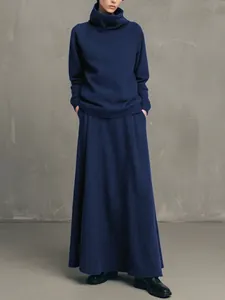 Minimalist navy blue high-neck sweatshirt and long skirt set shown on a model.