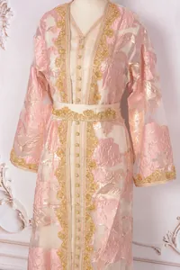 Close-up of a pink luxury party gown featuring intricate gold embroidery and beadwork details.