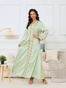 Vista de cuerpo entero de un vestido verde menta con bordados dorados y encaje.