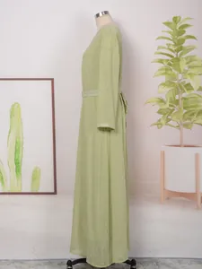 Vue latérale d'une robe longue verte avec dorure et détails de paillettes