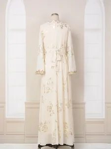 Vista trasera de elegante vestido largo crema con estampado floral dorado y lazo.