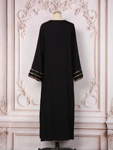 Robe longue élégante noire à manches longues avec détails de paillettes aux poignets.