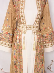 Detail of an elegant dress with heavy gold sequins, embroidery, and tassel belt.