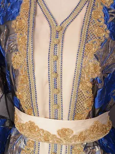 Close-up detail of golden heavy beadwork and embroidery on an elegant blue party dress