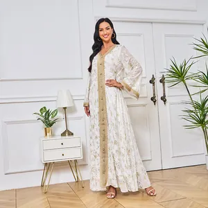 Élégante robe longue blanche avec imprimé floral doré et détails de garniture décoratifs