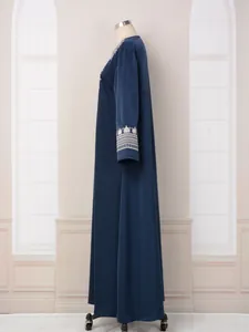 Vue latérale d'une robe caftan bleu marine avec broderie blanche sur les poignets.