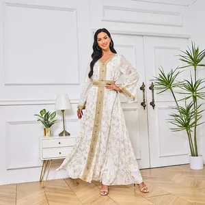 Robe maxi Abaya blanche élégante avec motif floral en feuille d'or et manches longues.