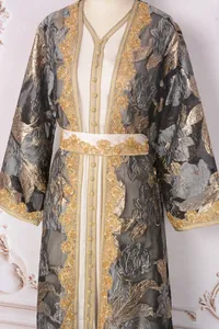 Macro view of luxurious gold floral embroidery and decorative beads on a black organza dress