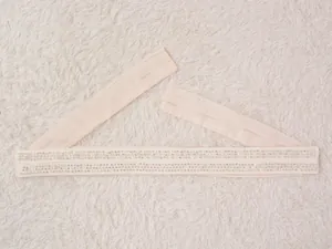 Détail d'une élégante ceinture de robe beige ornée de strass et de paillettes brillantes.
