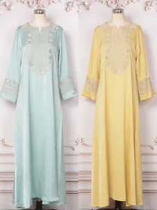 Vue détaillée de robes caftans maxi à manches longues brodées vert menthe et jaunes