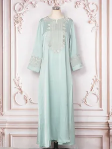 Vue détaillée d'une robe caftan brodée vert menthe clair avec des manches longues.