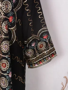 Nahaufnahme eines eleganten schwarzen Kleides mit bunter Blumenstickerei und Pailletten