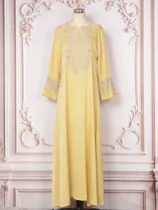 Robe longue caftan jaune élégante avec des broderies complexes en forme de cœur blanc.